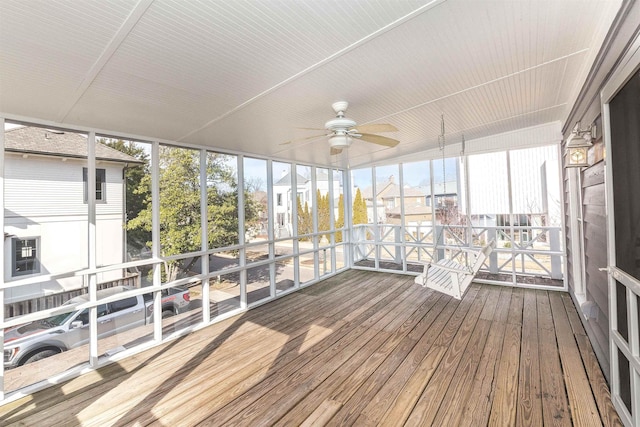 unfurnished sunroom with ceiling fan