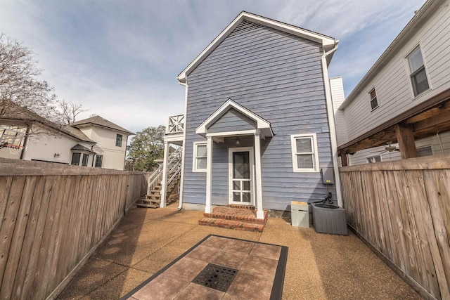 back of property with a patio and central AC