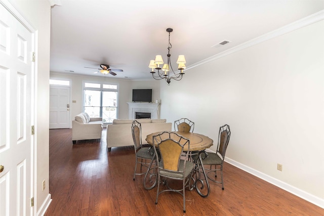 dining room featuring crown molding, dark hardwood / wood-style floors, and ceiling fan with notable chandelier