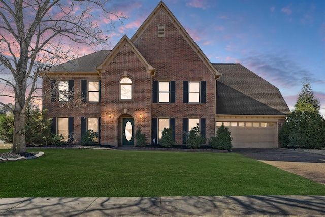 view of front of home with a yard and a garage