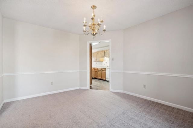 carpeted spare room featuring an inviting chandelier and sink