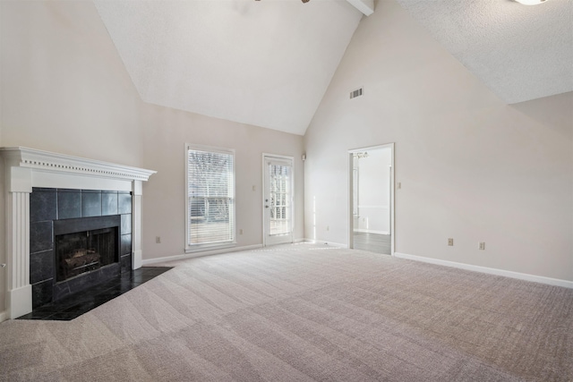 unfurnished living room featuring dark carpet, a fireplace, high vaulted ceiling, and beamed ceiling