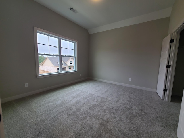 carpeted spare room with lofted ceiling