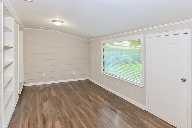 spare room with ornamental molding, dark hardwood / wood-style floors, and vaulted ceiling