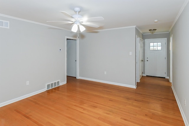 empty room featuring ceiling fan, ornamental molding, and light wood-type flooring