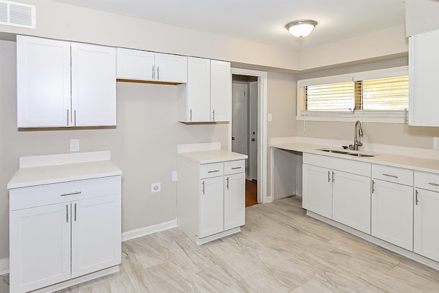 kitchen with white cabinetry and sink