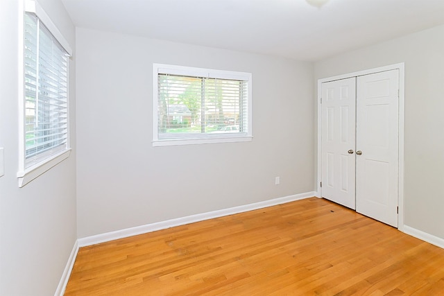 unfurnished bedroom featuring hardwood / wood-style flooring and multiple windows