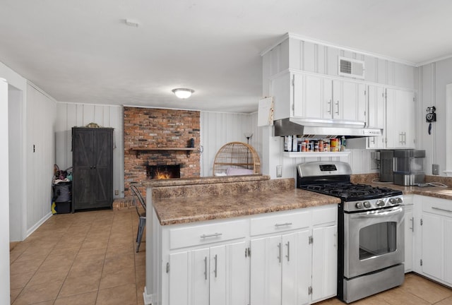 kitchen featuring extractor fan, white cabinetry, light tile patterned floors, kitchen peninsula, and gas stove