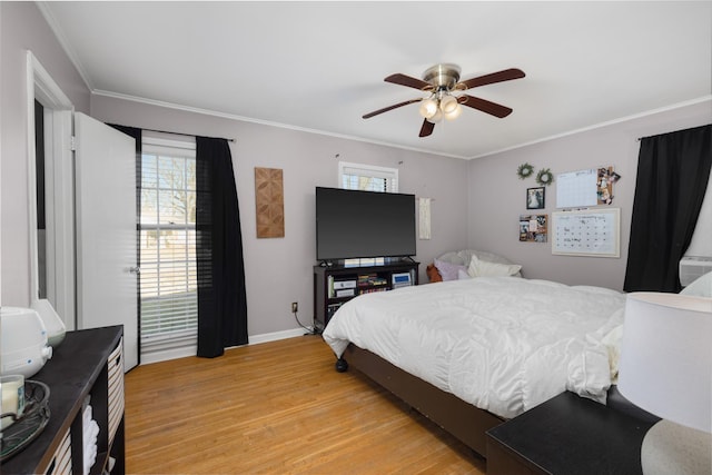 bedroom featuring multiple windows, ornamental molding, light hardwood / wood-style floors, and ceiling fan