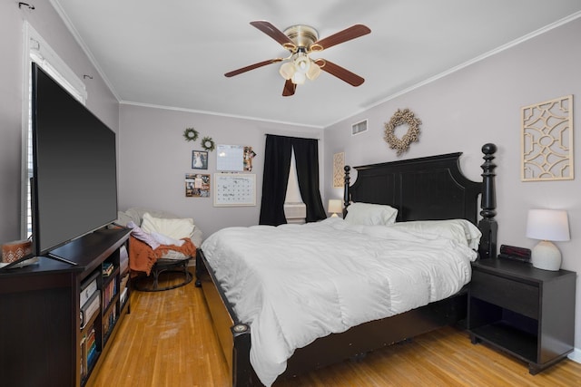 bedroom featuring ornamental molding, light wood-type flooring, and ceiling fan