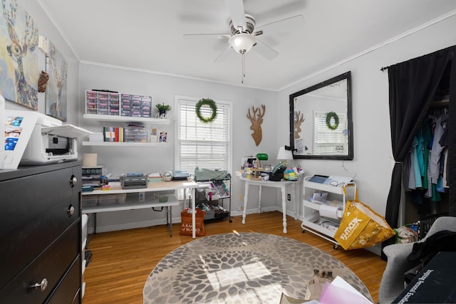 office area with wood-type flooring, ornamental molding, and ceiling fan