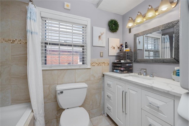 full bathroom with tile walls, vanity, toilet, tile patterned floors, and shower / bath combo with shower curtain