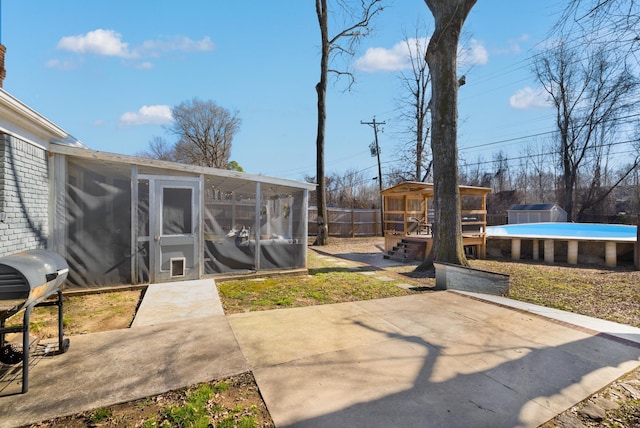 exterior space with a sunroom, a fenced in pool, and a patio