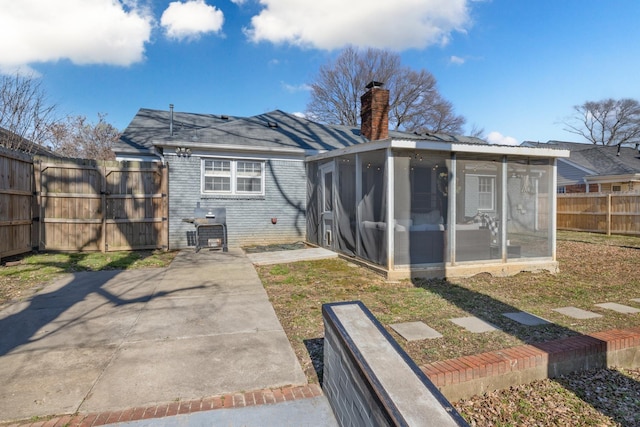 rear view of house with a patio area and a sunroom