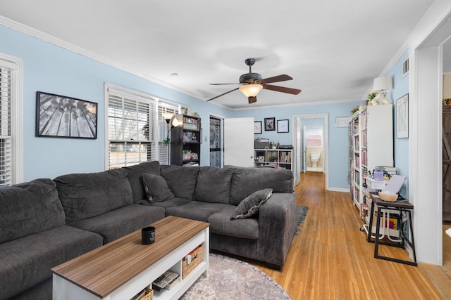 living room featuring ornamental molding, light hardwood / wood-style floors, and ceiling fan