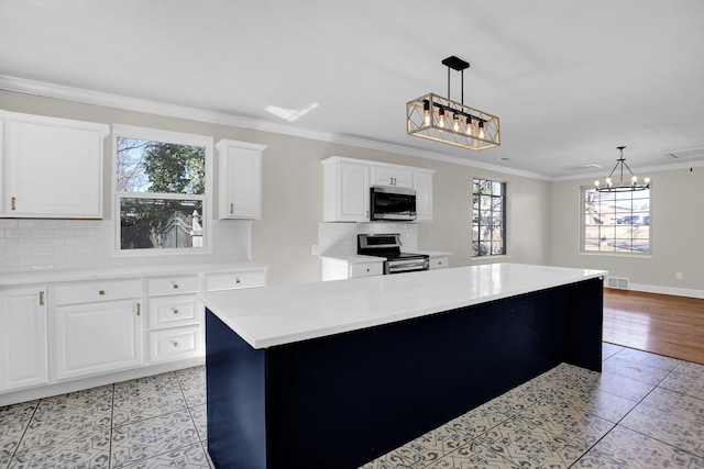 kitchen featuring stainless steel appliances, white cabinetry, a center island, and pendant lighting