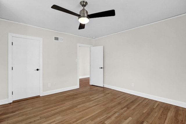 unfurnished bedroom with wood-type flooring, crown molding, and ceiling fan