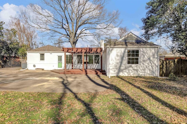 rear view of property featuring a yard, a pergola, and a patio