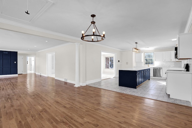 kitchen with blue cabinets, white cabinetry, decorative light fixtures, stainless steel dishwasher, and a kitchen island