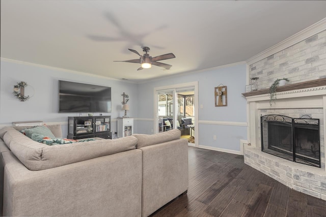 living room with crown molding, a fireplace, dark hardwood / wood-style floors, and ceiling fan