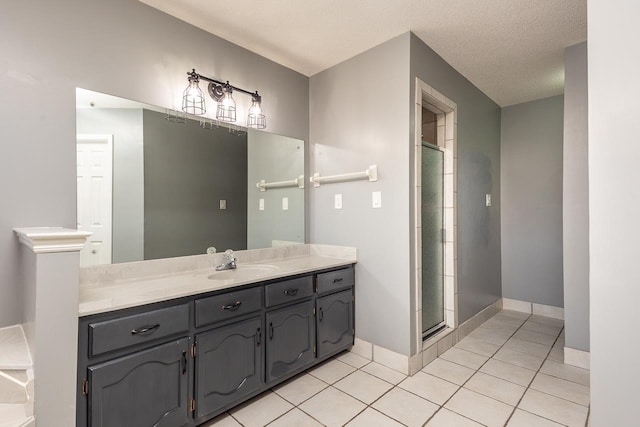 bathroom featuring a shower with door, vanity, tile patterned floors, and a textured ceiling