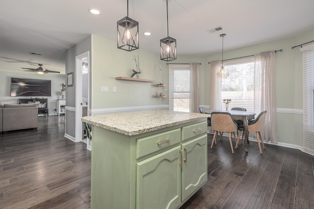 kitchen with a kitchen island, decorative light fixtures, dark hardwood / wood-style flooring, green cabinets, and ceiling fan