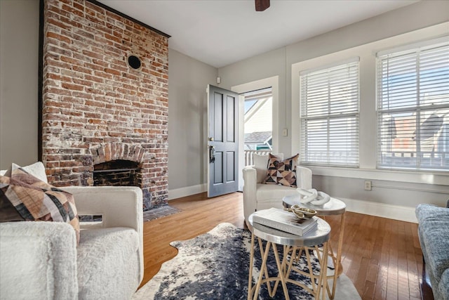 living room featuring a brick fireplace and light hardwood / wood-style flooring