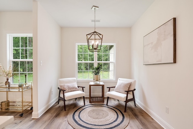 sitting room featuring an inviting chandelier and wood-type flooring