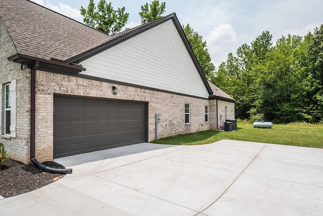 view of property exterior featuring central AC unit, a garage, and a lawn