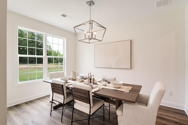 dining area featuring an inviting chandelier and hardwood / wood-style floors