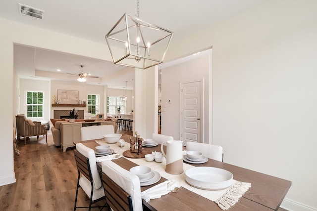 dining area featuring ceiling fan with notable chandelier and hardwood / wood-style floors