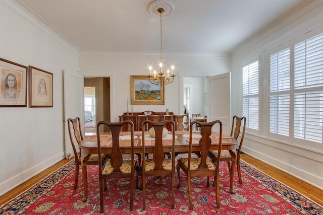 dining room with crown molding, hardwood / wood-style floors, and an inviting chandelier