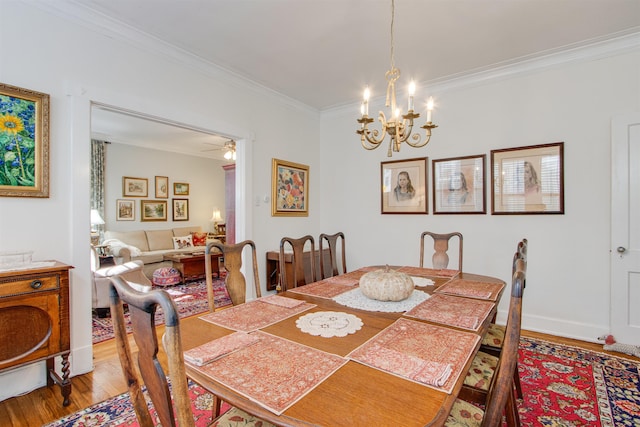 dining area with ornamental molding, ceiling fan with notable chandelier, and hardwood / wood-style floors