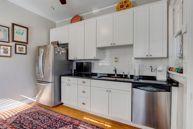 kitchen with stainless steel appliances, sink, and white cabinets