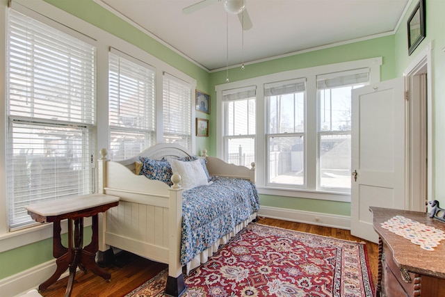 interior space featuring multiple windows, ornamental molding, dark wood-type flooring, and ceiling fan