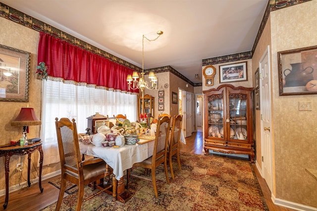 dining space featuring dark wood-type flooring, crown molding, and a chandelier