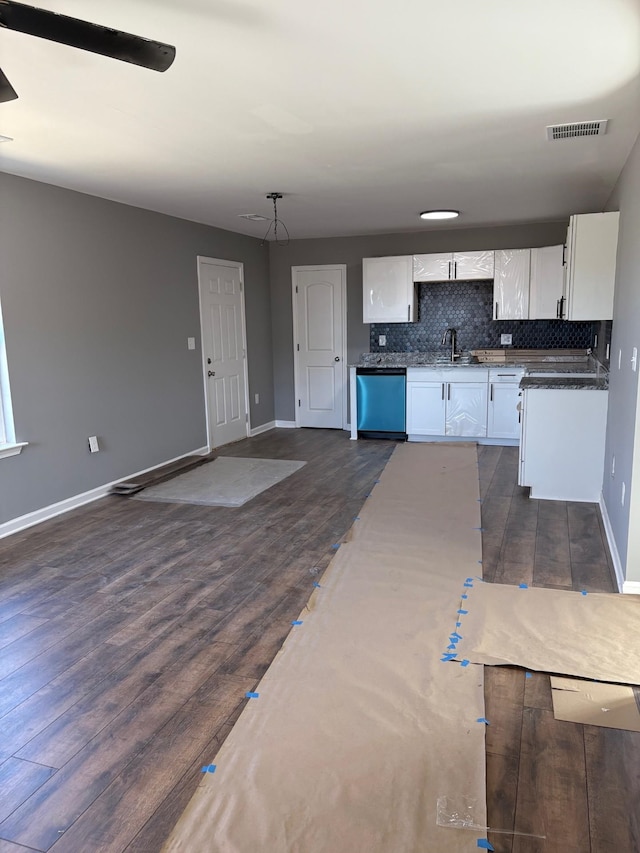 kitchen with dark wood-type flooring, sink, white cabinetry, tasteful backsplash, and dishwashing machine