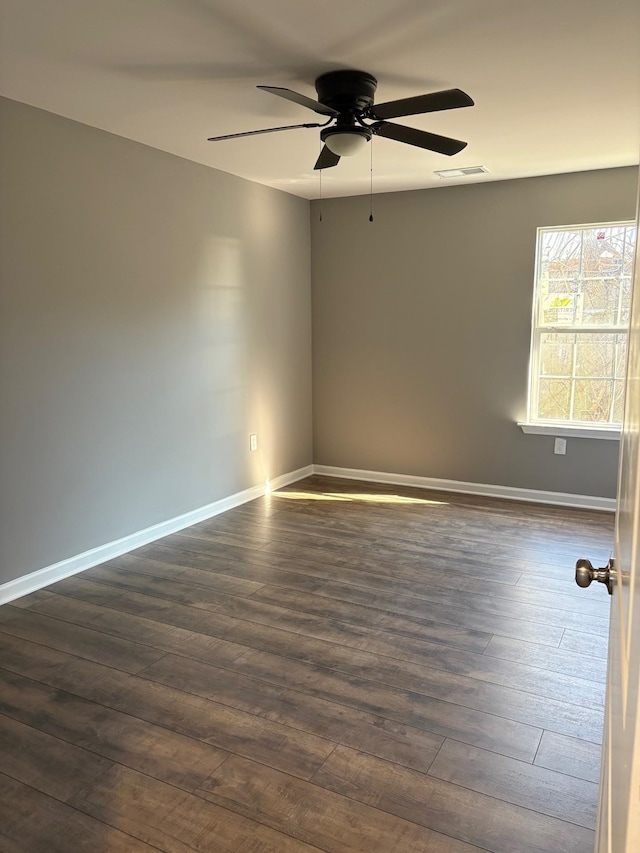 unfurnished room featuring dark wood-type flooring and ceiling fan