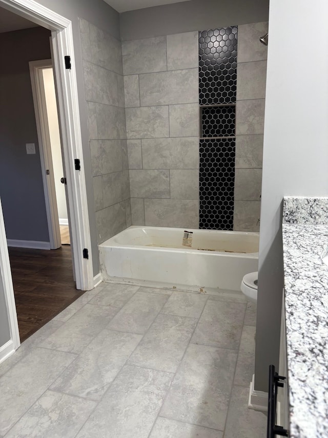 full bathroom with tiled shower / bath combo, vanity, and toilet