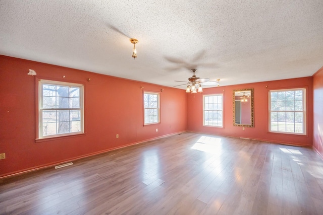 empty room featuring hardwood / wood-style flooring, ceiling fan, and a textured ceiling