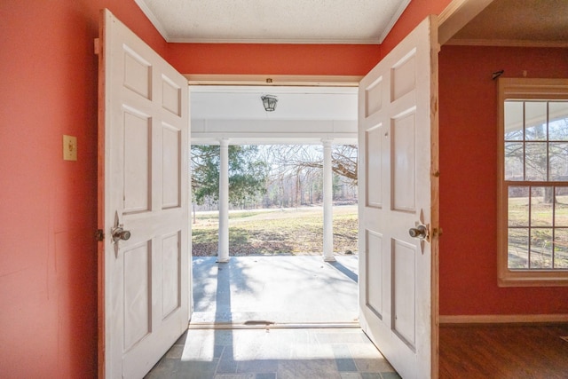 foyer featuring crown molding, a textured ceiling, and a wealth of natural light