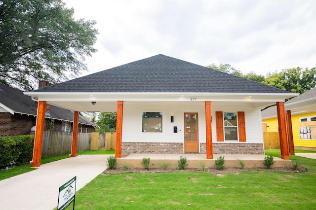 view of front facade featuring covered porch and a front lawn