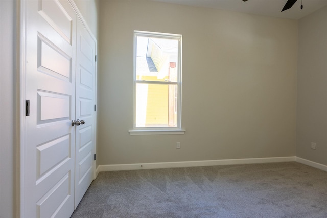 carpeted empty room featuring ceiling fan