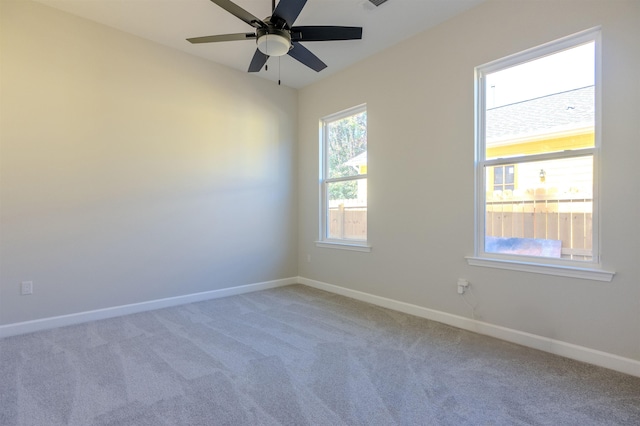 carpeted spare room featuring ceiling fan