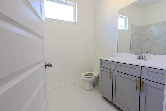 bathroom featuring toilet, vanity, and a wealth of natural light