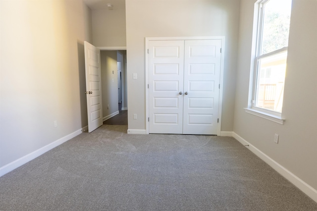 unfurnished bedroom featuring a closet and light colored carpet