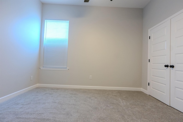 spare room featuring light colored carpet and ceiling fan