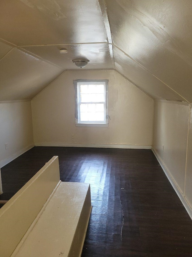 bonus room featuring dark wood-type flooring and vaulted ceiling