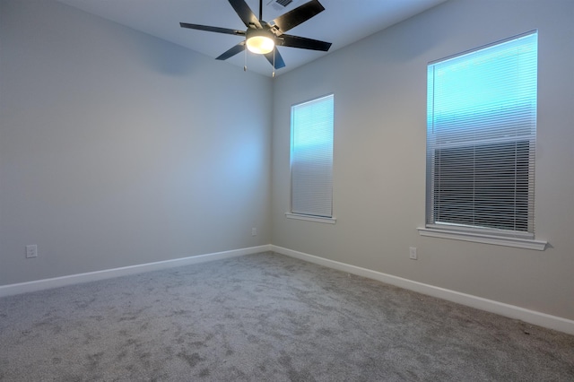 spare room with ceiling fan and carpet