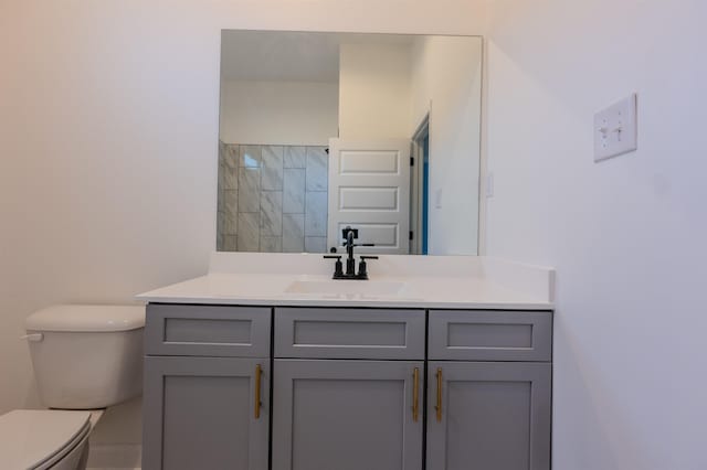 bathroom with toilet, vanity, and walk in shower